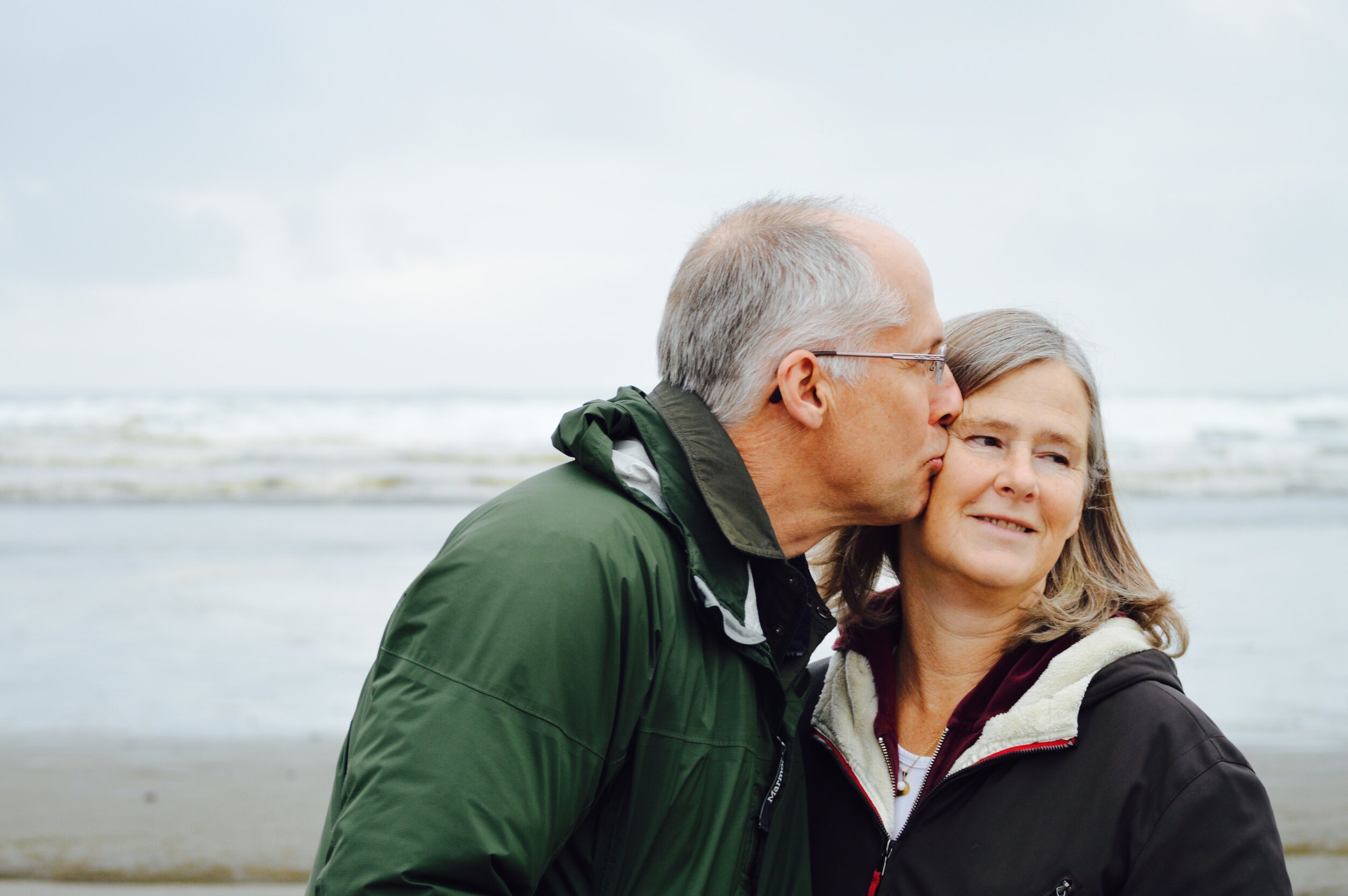 A retired couple enjoying a walk on the beach